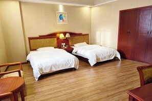 A hotel room with two single beds, a wooden wardrobe, a small table, and a chair. - Yongheng Business Hotel (Debao)