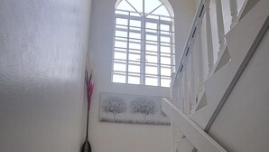 Eine Treppe mit weißen Geländern und einem Fenster am oberen Ende.
