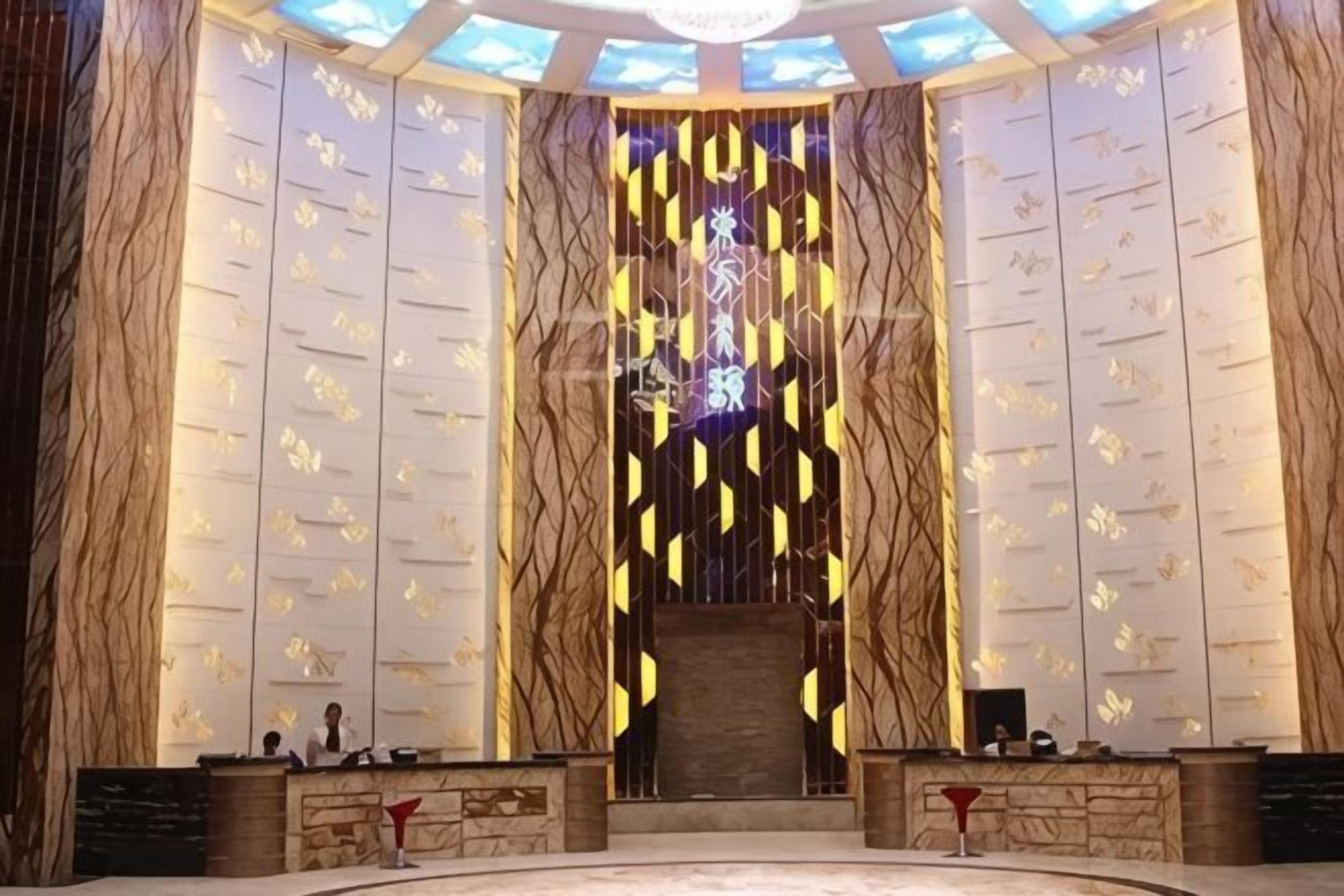 A reception area with a central staircase, a wall with vertical text, and two reception desks.