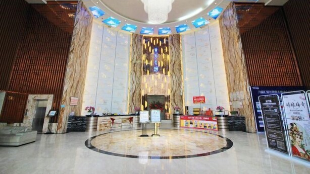 A spacious lobby with a central chandelier, a reception desk, and a digital display. - Dongfang Shuiyun Spa Hotel (Qingyuan)