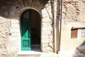 Traditional stone building with a distinctive door and small window.