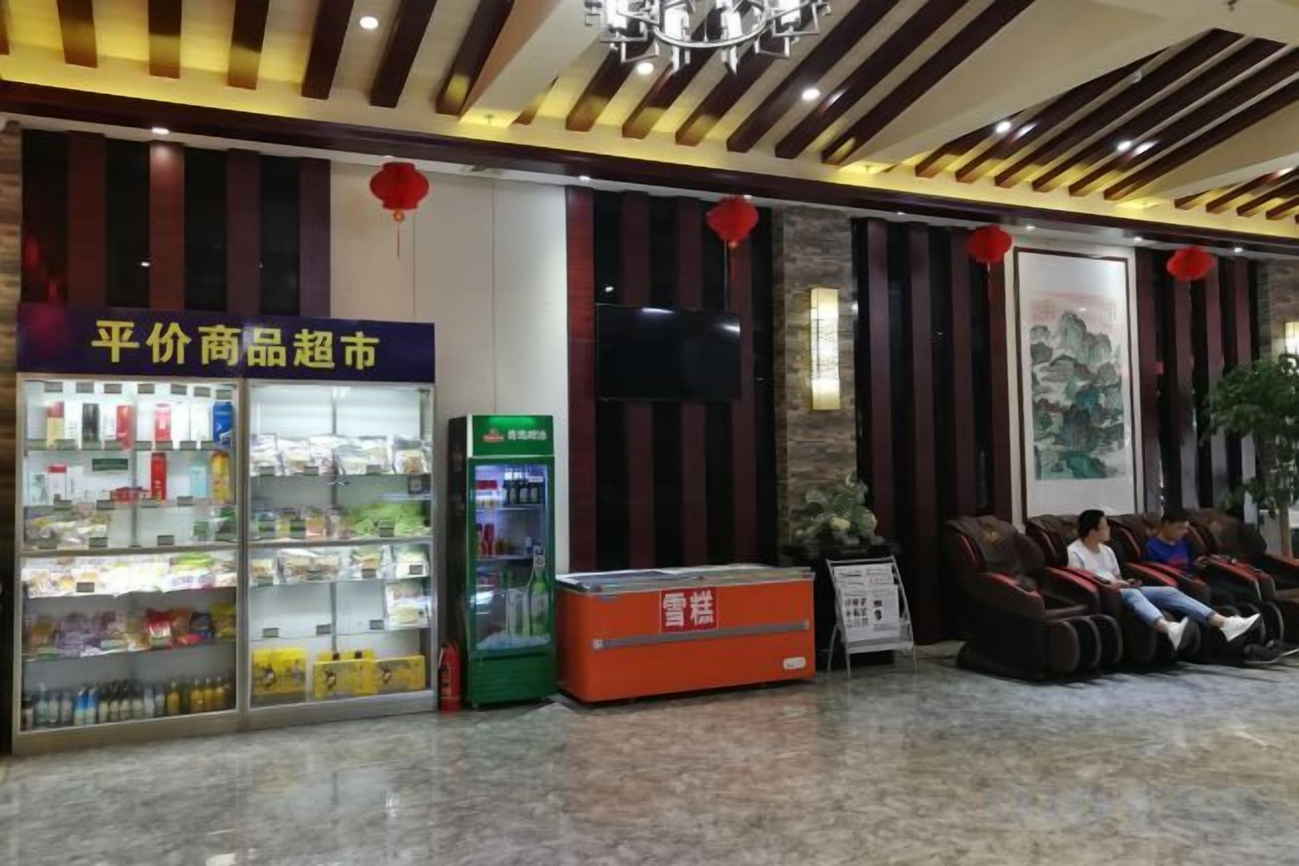 A hotel lobby with a massage chair area, a snack kiosk, and a large poster on the wall.