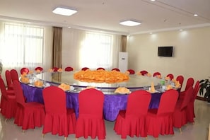 A conference room with a round table, red chairs, and a television on the wall. - Hantang Tianrun Hotel (Weihai)