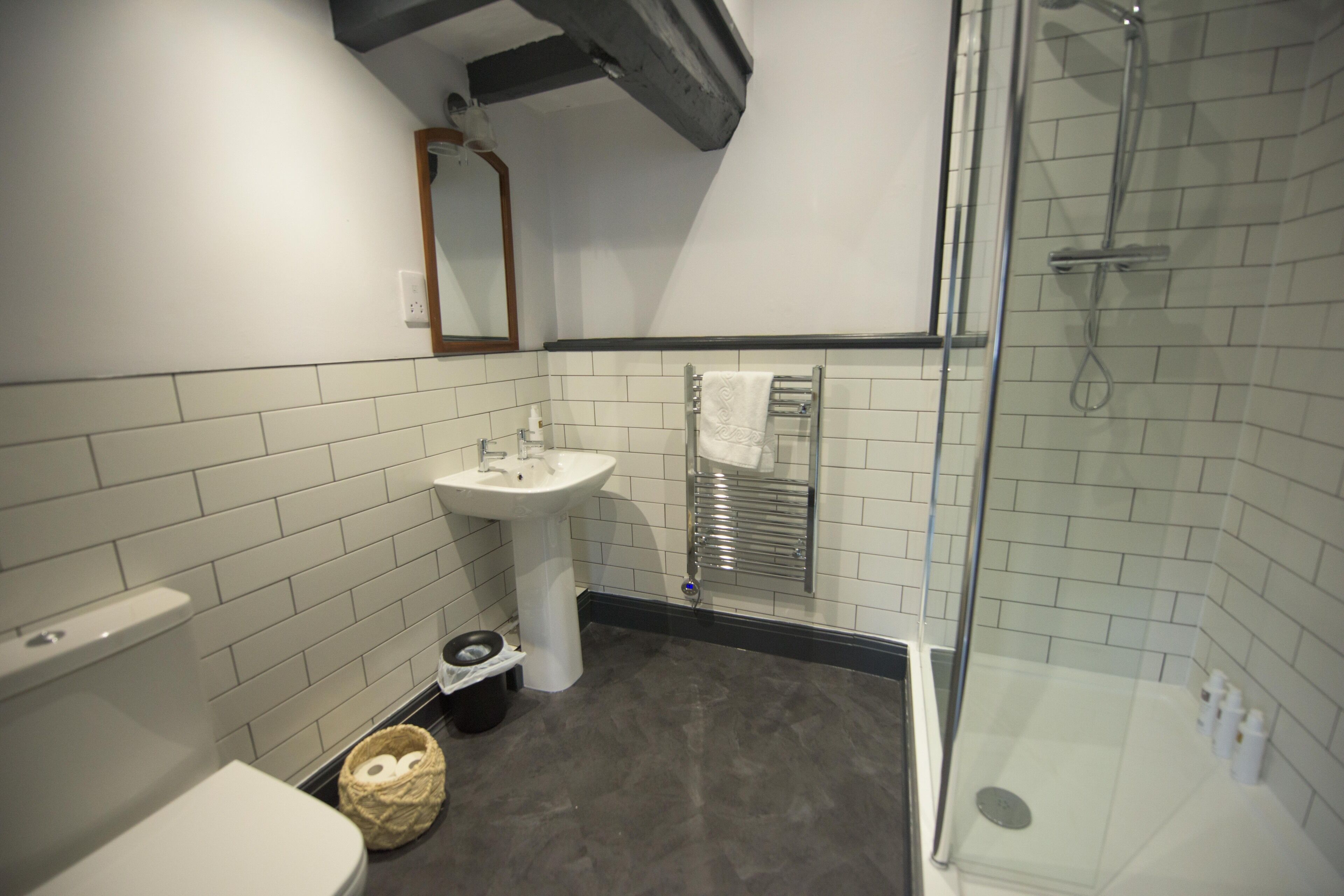 A bathroom with a toilet, sink, and shower.
