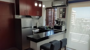 A modern kitchen with a central island, stainless steel appliances, and wooden cabinets. - Le Petit Coeur • Beautiful Ocean View Romantic Zone (Puerto Vallarta)