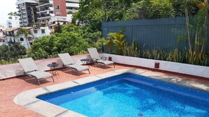 A rooftop pool with four lounge chairs and a tiled deck. - Le Petit Coeur • Beautiful Ocean View Romantic Zone (Puerto Vallarta)