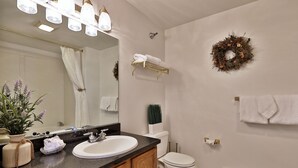 Un baño con lavamanos, espejo, toallero, inodoro y coronas decorativas.
