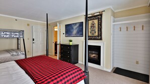 Un dormitorio con cama con dosel, chimenea, armario y puerta.