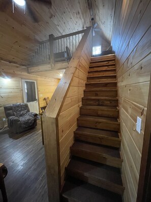 Una scala in legno con corrimano che conduce a un piano superiore.