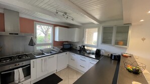 Een moderne keuken met witte kasten, een zwart aanrecht en een raam dat natuurlijk licht binnenlaat.