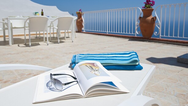 A sunlit terrace with a table, chairs, and a book with sunglasses on it. - House "Le Anfore" - Amalfi Coast (Conca dei Marini)