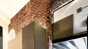 A modern kitchen with a brick accent wall, built-in appliances, and a herringbone-patterned floor. - Lancetti Stylish Loft (Milan)