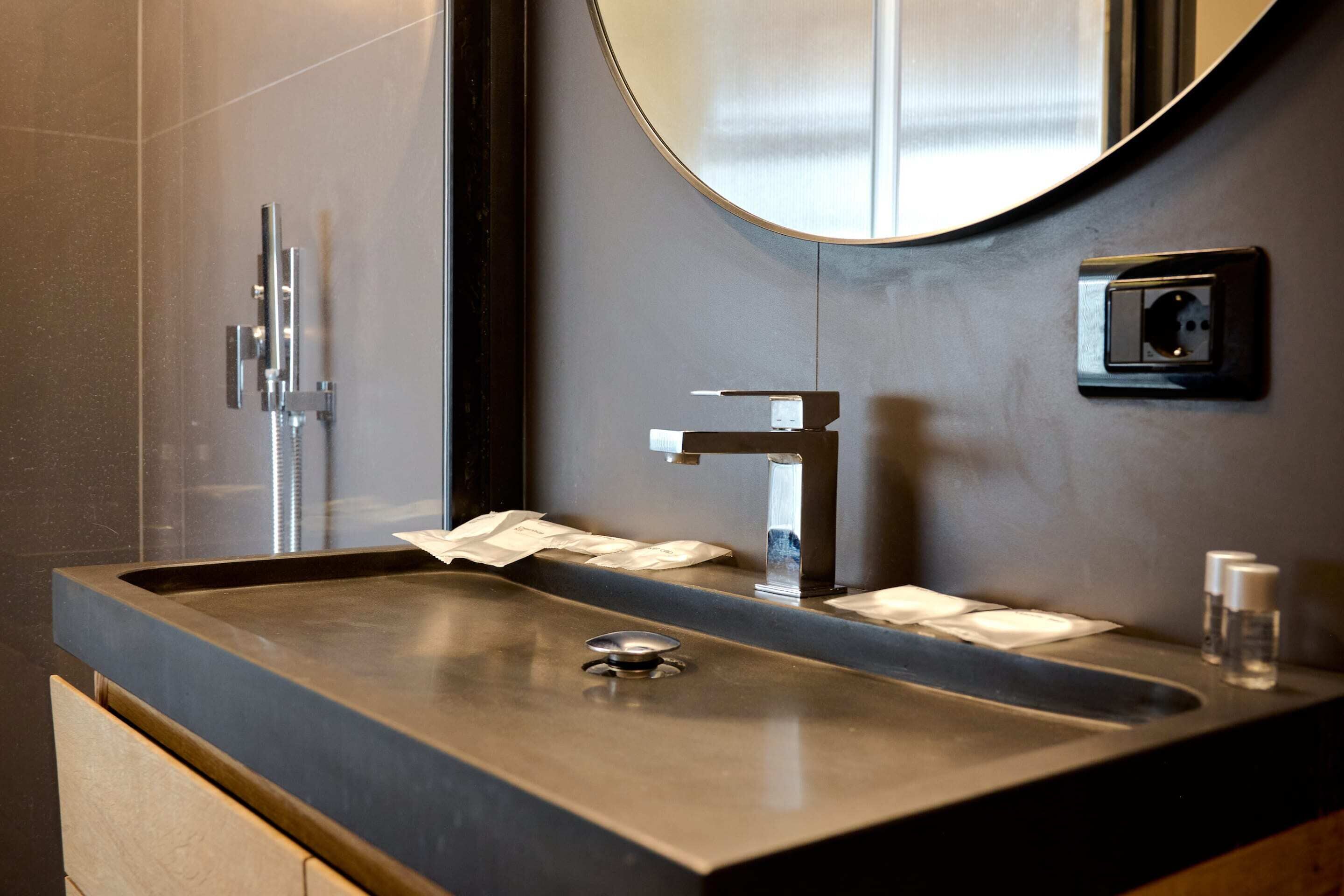 Een moderne badkamer met een groot wastafel, een spiegel en een douche.