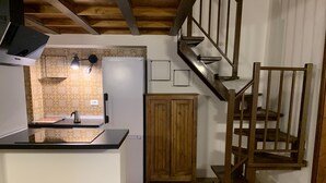Una cocina con una escalera de madera y un armario de madera.