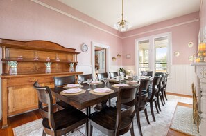 Een eetkamer met een houten tafel voor zes personen, omringd door stoelen.