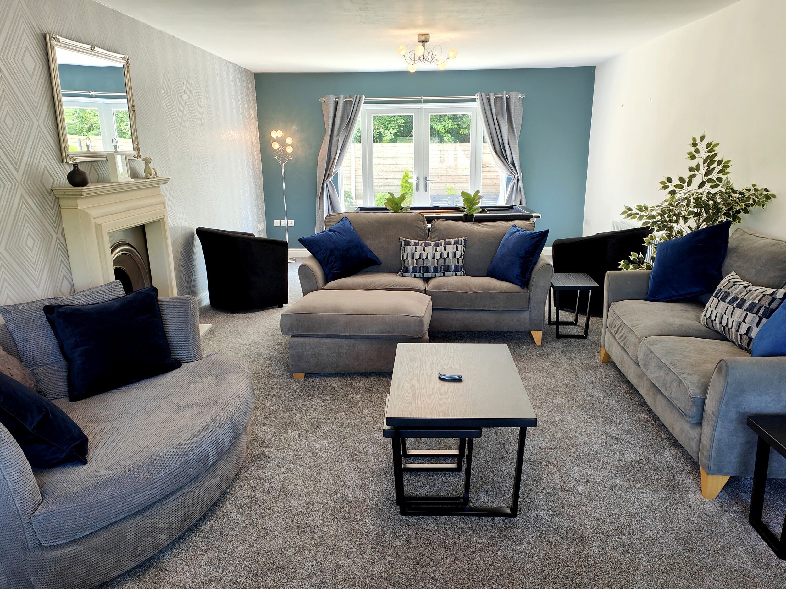 A living room with a sectional sofa, a coffee table, and a fireplace.