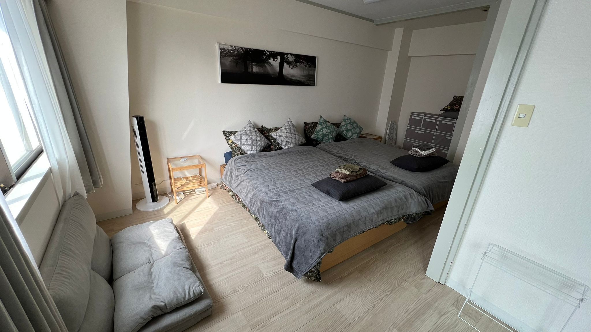 A bedroom with a bed, bedside table, and a window.