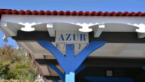 Ein Gebäude mit einem Schild, auf dem „AZUR“ steht, unter einem roten Ziegeldach.