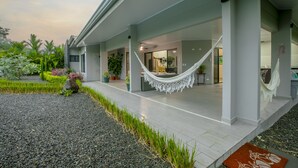 A modern building with a covered outdoor area, a hammock, and a well-maintained garden. - Villa Margarita - Families Getaway in La Fortuna (La Fortuna)