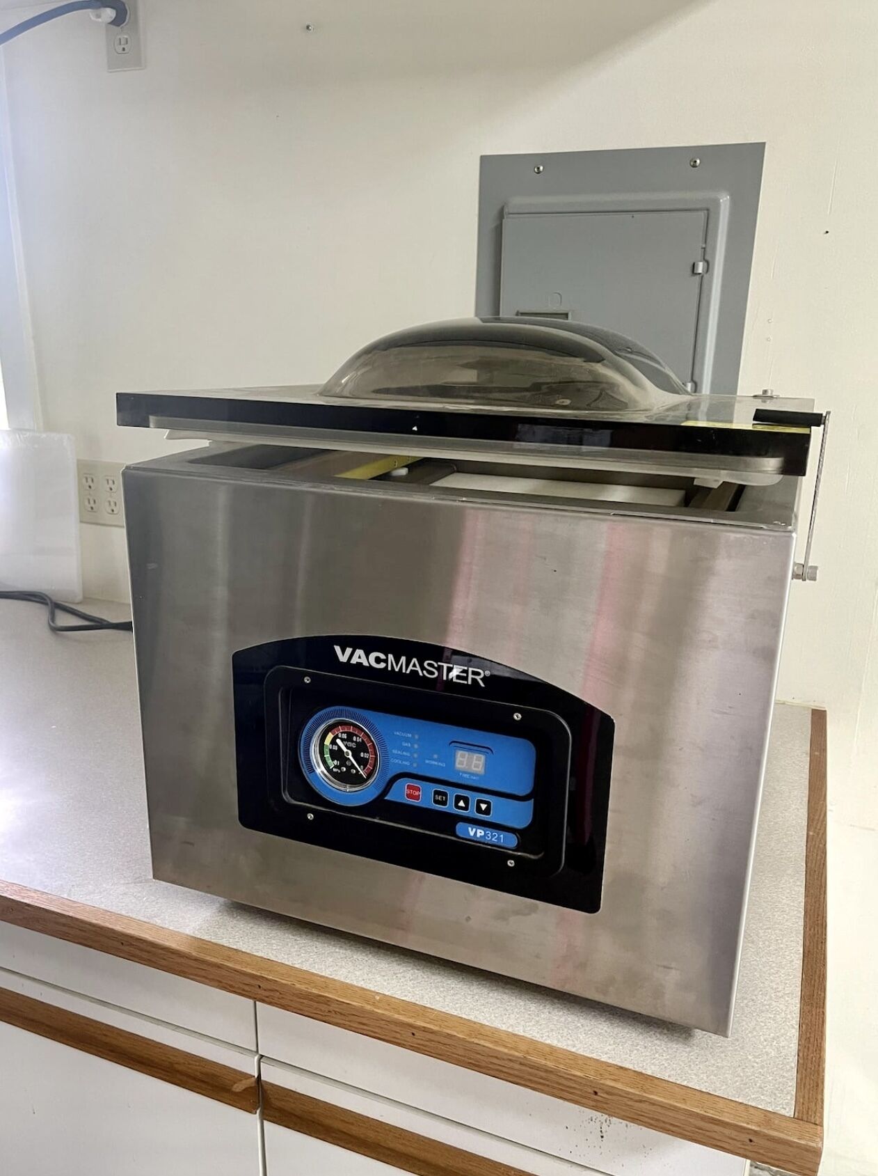 Un aspirateur en acier inoxydable doté d’un écran numérique et d’un bac à poussière transparent.
