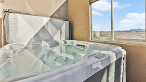 A hot tub with a clear view of the desert landscape through a window. - Nelly: Pet Friendly + Private Hot Tub + Sand Dunes (Hurricane)