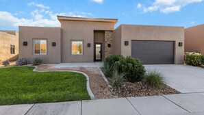 A modern two-story house with a garage, a landscaped front yard, and a clear sky. - Nelly: Pet Friendly + Private Hot Tub + Sand Dunes (Hurricane)