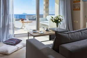 Un salon moderne avec un canapé, une table basse et une vue sur la mer.