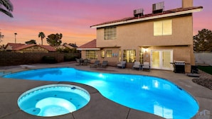 A two-story house with a swimming pool, outdoor seating, and a hot tub. - Warm 4BR W/ Loft home, 15min to strip, Near Summerlin! Pool & Spa! Pet Friendly! (Las Vegas)