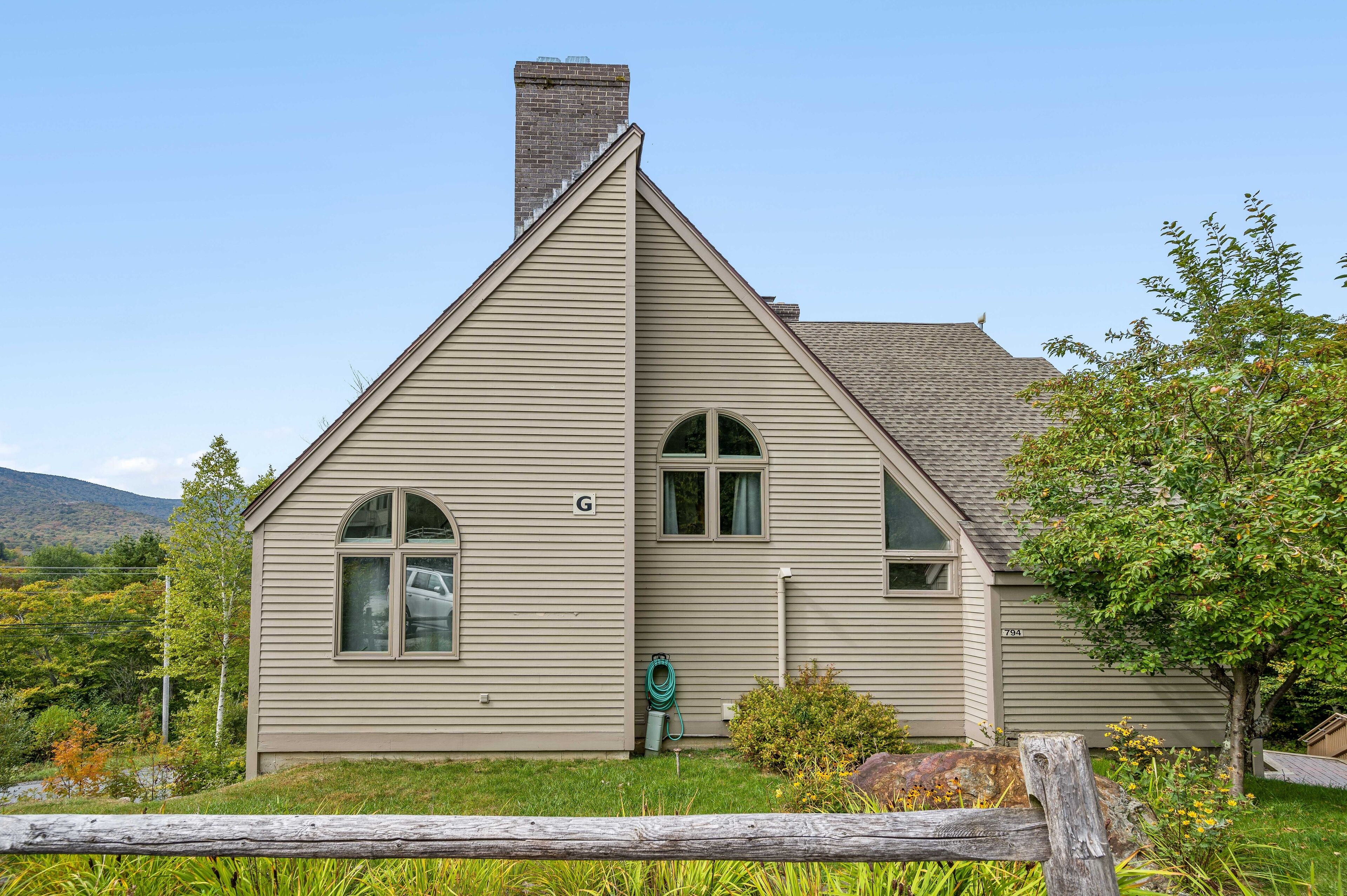 A single-story house with a gabled roof, a chimney, and a garage door.