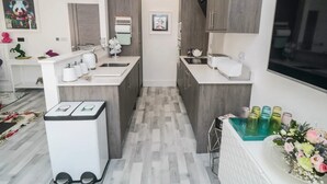 Une cuisine moderne dotée d’un îlot central, d’appareils électroménagers intégrés et d’un petit coin salon.