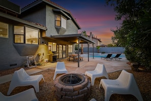 A house with a patio, outdoor seating, a fire pit, and a pool.
