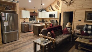 A cozy cabin-style interior with a kitchen, dining area, and living room.