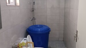 Een kleine badkamer met toilet, wastafel en douche.