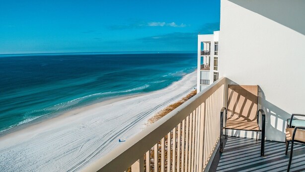 A balcony with a view of a beach and ocean. - Pelican Beach 1510 1 Bedroom Condo by Pelican Beach Management (Destin)