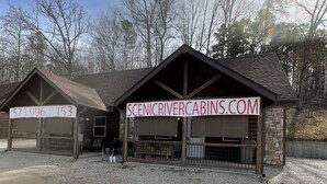 Une cabane avec une allée en gravier et un panneau indicateur.