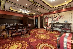 A traditional room with a patterned carpet, wooden furniture, and a decorative wall.