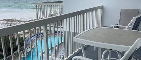 Un balcón con vista a una piscina y una playa.