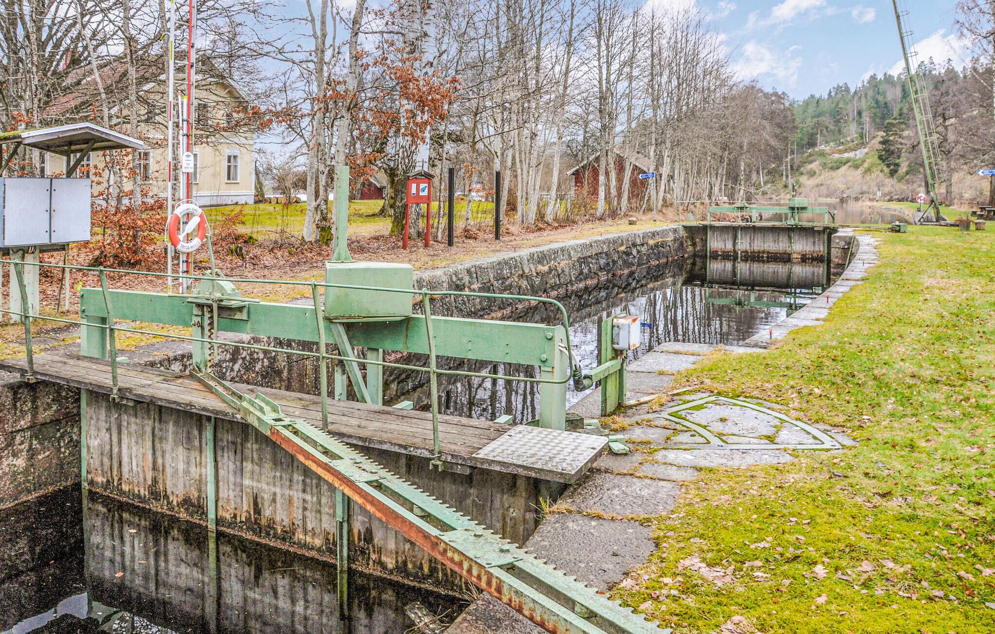 A lock system with a concrete lock chamber, metal gates, and a wooden walkway.