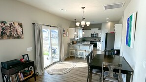 A spacious kitchen with a dining area, large windows, and a view of the outdoors. - Masters Rental (Aiken)