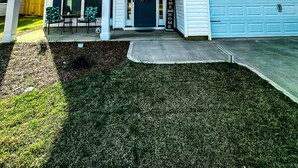 A two-story house with a front porch, a garage, and a well-maintained lawn. - Masters Rental (Aiken)