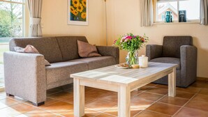 A living room with a sofa, armchair, and a coffee table. - Gorgeous home in IJhorst with WiFi (IJhorst)