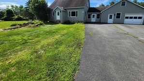 A two-story house with a paved driveway and a well-maintained lawn. - Riverfront, family fun, amazing rec room, close to Magic & Okemo (Chester)
