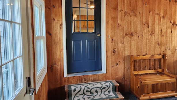 A wooden door with a window above it, a bench, and a mat at the entrance. - Riverfront, family fun, amazing rec room, close to Magic & Okemo (Chester)