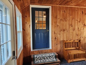 A wooden door with a window above it, a bench, and a mat at the entrance. - Riverfront, family fun, amazing rec room, close to Magic & Okemo (Chester)
