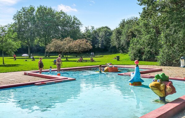 Relax by the pool surrounded by whimsical sculptures and lush greenery.