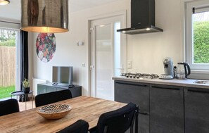 Enjoy cooking in this well-equipped kitchen with a gas stove, coffee maker, and dining area nearby.