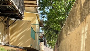 A narrow alleyway with buildings on either side, potted plants, and a visible mailbox. - Extraordinary panoramic  (Bastia)