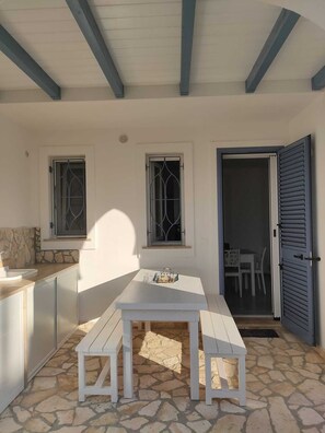 Enjoy meals al fresco in this charming outdoor dining area with a table and benches.