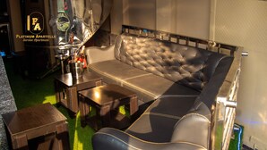 A modern living room with a leather sofa, a glass coffee table, and a small wooden side table. - Platinum Apartelle  (Benin City)