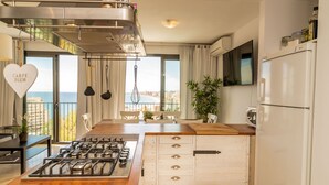 Une cuisine moderne équipée d’une cuisinière à gaz, de meubles en bois et offrant une vue sur la ville.